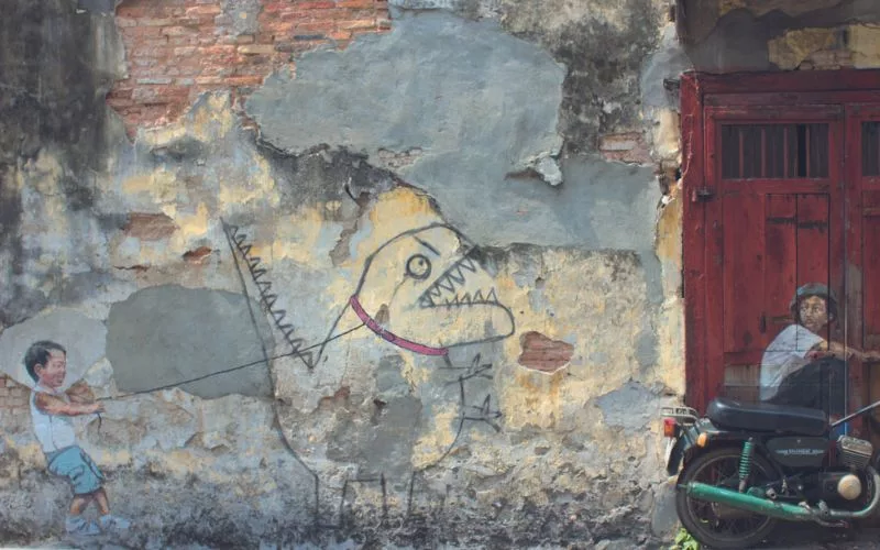 Penang street art boy holding dinosaur pet